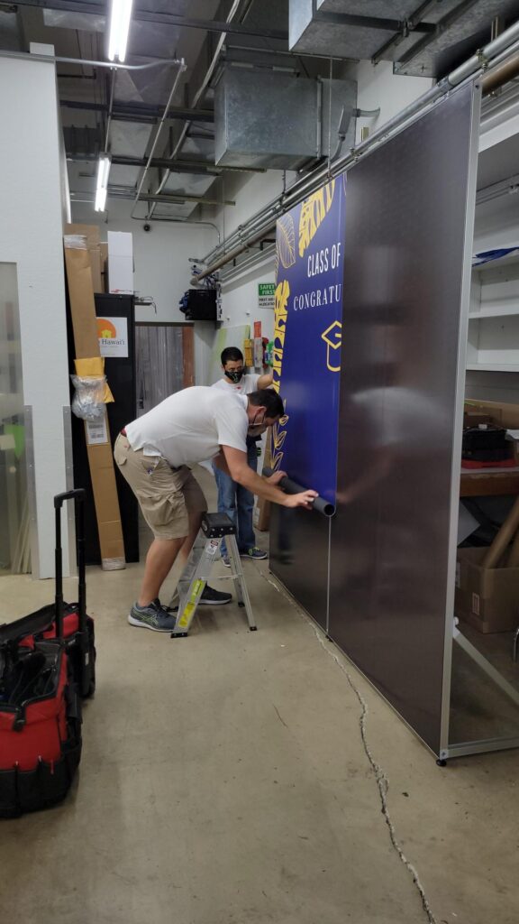 Man bending down to install graphic on wall