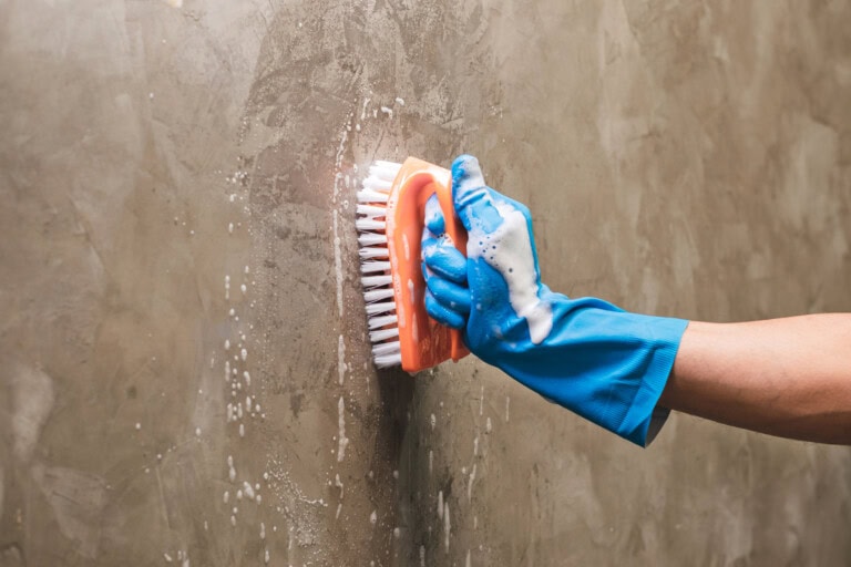 Closeup hand wearing blue glove scrub cleaning wall